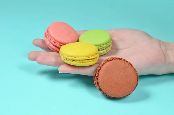 Colored Macaroons Hand Close Blue Backgroun — Stock Photo, Image