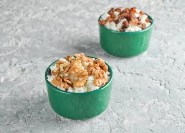 Kuru üzüm ve ceviz bir gri beton tabloda süzme peynir seramik kâse