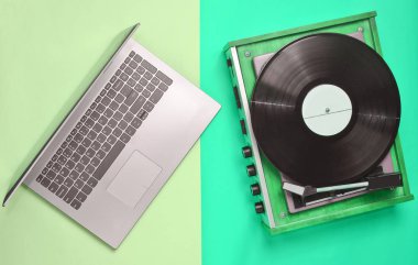 Dizüstü bilgisayar, pastel renkli bir arka plan üzerinde vinil oyuncu. Modern ve eski teknoloji, top vie