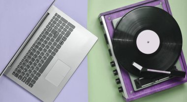Dizüstü bilgisayar, pastel renkli bir arka plan üzerinde vinil oyuncu. Modern ve eski teknoloji, top vie