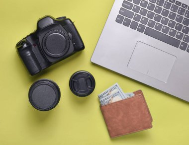 Ekipman fotoğrafçı, dizüstü bilgisayar, çanta dolar üzerinde yeşil bir arka plan ile. Serbest kavramı, fotoğrafçının çalışmaları, nesneleri, üstten görünüm, düz la