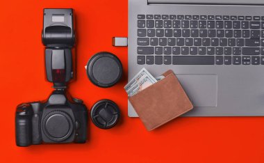 Ekipman fotoğrafçı, dizüstü bilgisayar, çanta dolar üzerinde sarı bir arka plan ile. Serbest kavramı, fotoğrafçının çalışmaları, nesneleri, üstten görünüm, düz la