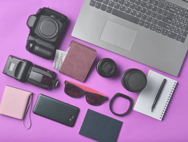 Ekipman fotoğrafçı, laptop, dolar, smartphone, akıllı izle, pasaport, sarı arka plan üzerinde güç banka ile çanta. Serbest kavramı, iş ve seyahat, nesneleri, üst görünümden, düz la için gadgets