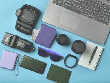 Ekipman fotoğrafçı, laptop, dolar, smartphone, akıllı izle, pasaport, sarı arka plan üzerinde güç banka ile çanta. Serbest kavramı, iş ve seyahat, nesneleri, üst görünümden, düz la için gadgets