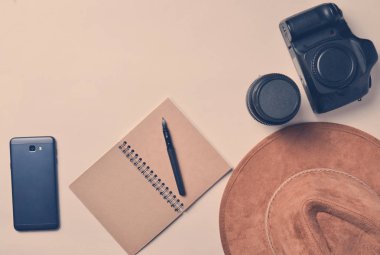 Foto muhabiri eseri. Smartphone, defter, şapka, kamera, lens. Seyahat kavramı, üstten görünüm, düz la