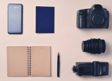 Foto muhabiri. Smartphone, defter, pasaport, kamera. Seyahat kavramı, üstten görünüm, düz la