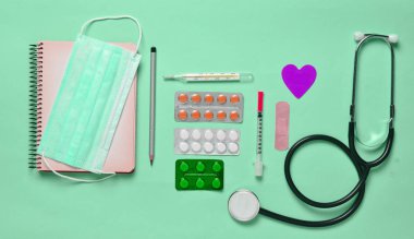 Tıbbi malzeme mavi bir arka plan üzerinde. Kabarcıklar hapları, Not defteri, stetoskop, şırınga, termometre. Tıbbi kavramı, üstten görünüm, düz yatıyordu styl