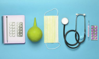 Tıbbi ekipman pembe bir arka plan üzerinde. Lavman, balon hapları, Not defteri, stetoskop, termometre. Tıbbi kavramı, üstten görünüm, düz yatıyordu stil, kopyalama alanı