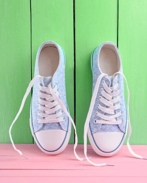 Weibliche Füße in Gum Schuhe auf hölzernen Hintergrund Farbe Weibliche Füße in Gum Schuhe auf hölzernen Hintergrund Farbe