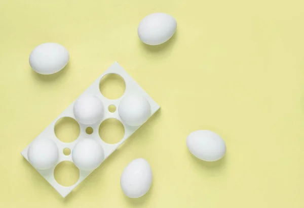 Plastic tray with white eggs on a blue pastel background, minimalism trend, top vie