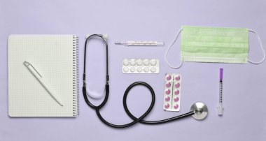 Tıbbi ekipman üzerinde bir pastel pembe. Kabarcıklar hapları, Not defteri, stetoskop, termometre, manometre. Tıbbi kavramı, üstten görünüm, düz yatıyordu styl