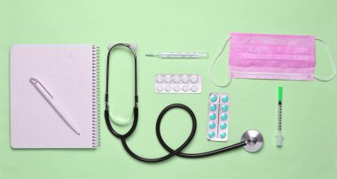 Tıbbi ekipman üzerinde bir pastel pembe. Kabarcıklar hapları, Not defteri, stetoskop, termometre, manometre. Tıbbi kavramı, üstten görünüm, düz yatıyordu styl