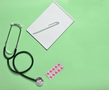 Notebook, tablet ve pastel mavi arka plan, minimalist eğilim, üstten görünüm, tıbbi workplac sağlık stetoskop