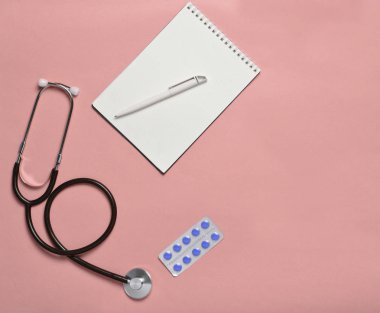 Notebook, tablet ve pastel mavi arka plan, minimalist eğilim, üstten görünüm, tıbbi workplac sağlık stetoskop