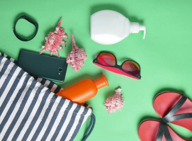 Plaj çantası ve aksesuarları pastel mavi arka plan üzerinde plaj düzendeki rahatlamak için. Deniz, yaz saati Resort'ta kavramı. Üstten görünüm, düz yatıyordu, minimalis