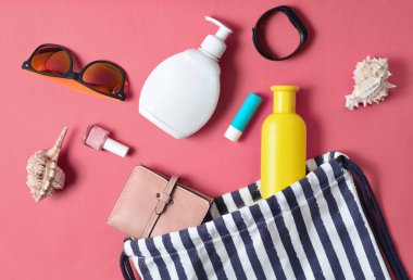 Plaj çantası ve aksesuarları pastel pembe plaj düzenine rahatlamak için. Deniz, yaz saati Resort'ta kavramı. Üstten görünüm, düz yatıyordu, minimalis