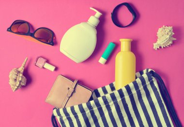 Plaj çantası ve aksesuarları pastel pembe plaj düzenine rahatlamak için. Deniz, yaz saati Resort'ta kavramı. Üstten görünüm, düz yatıyordu, minimalis