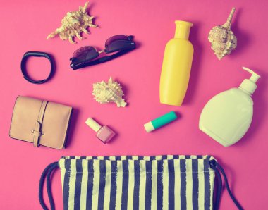 Plaj çantası ve aksesuarları pastel pembe plaj düzenine rahatlamak için. Deniz, yaz saati Resort'ta kavramı. Üstten görünüm, düz yatıyordu, minimalis