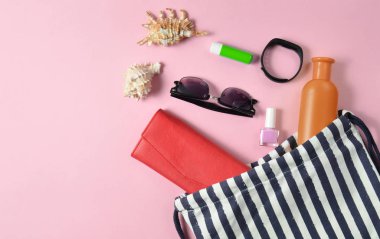 Plaj çantası ve aksesuarları pastel pembe plaj düzenine rahatlamak için. Deniz, yaz saati Resort'ta kavramı. Üstten görünüm, düz yatıyordu, minimalis