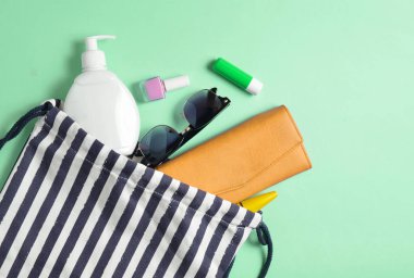 Plaj çantası ve aksesuarları pastel mavi arka plan üzerinde plaj düzendeki rahatlamak için. Deniz, yaz saati Resort'ta kavramı. Üstten görünüm, düz yatıyordu, Minimalizm, kopya girintili