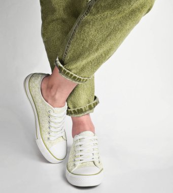 Kadın bacaklar kısa kot pantolon ve spor ayakkabı beyaz bir adam üzerinde durun