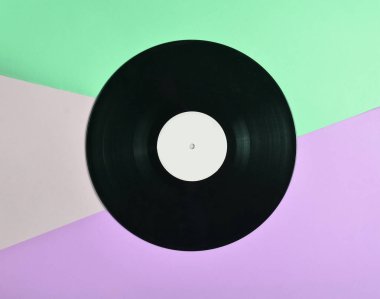 Vinil plaka üzerinde pastel renkli arka plan, retro müzik teknolojisi, üstten görünüm, minimalis