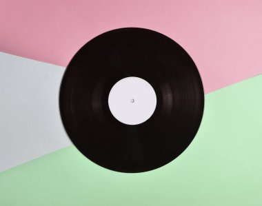 Vinil plaka üzerinde pastel renkli arka plan, retro müzik teknolojisi, üstten görünüm, minimalis