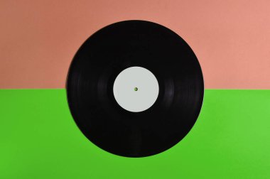 Vinil plaka üzerinde pastel renkli arka plan, retro müzik teknolojisi, üstten görünüm, minimalis