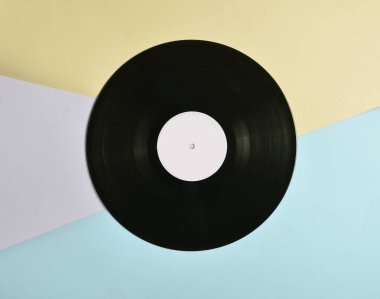 Vinil plaka üzerinde pastel renkli arka plan, retro müzik teknolojisi, üstten görünüm, minimalis