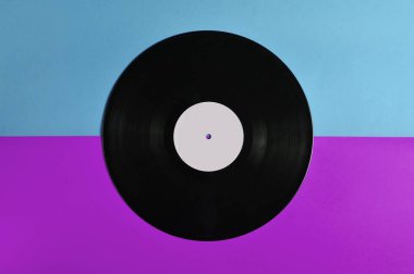 Vinil plaka üzerinde pastel renkli arka plan, retro müzik teknolojisi, üstten görünüm, minimalis