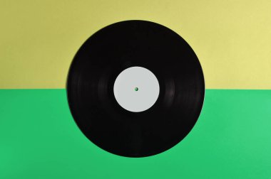 Vinil plaka üzerinde pastel renkli arka plan, retro müzik teknolojisi, üstten görünüm, minimalis