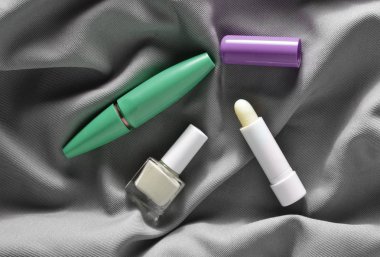 Kadın kozmetik: maskara gözleri, tırnak cilası, gri ipek kumaş, üst üzerinde hijyenik ruj için vie