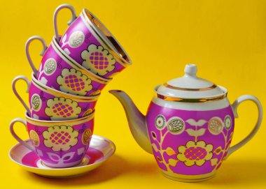 Retro bardak ve çaydanlık sarı bir arka plan üzerine yığını