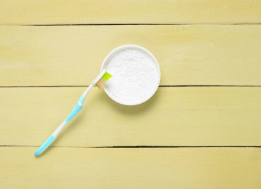 Diş tozu ve mavi ahşap bir masa üzerinde bir diş fırçası. Oral hijyen