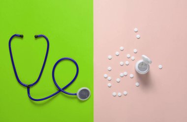 Steteskop ve şişe ile hapları bir renkli arka plan, tıbbi kavramı, üstten görünüm