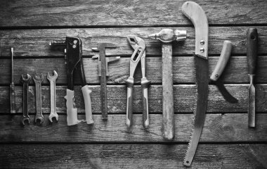 Ahşap bir masa üzerinde bir çalışma aracı. Testere, çekiç, tornavida, pense, dimes, bıçak, top vie