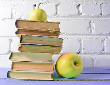 Eski kitaplar, beyaz tuğla duvar arka plan üzerinde elma yığını. Okul kavramı, eğitim