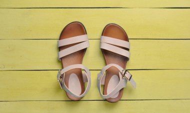 Şık Kadın sandalet sarı ahşap zemin üzerinde. Üstten görünüm
