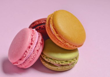 Birçok macaroons pastel pembe bir arka plan üzerinde. Minimalis