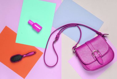 Deri çanta, tarak, pastel renkli bir arka plan üzerinde parfüm şişesi. Minimalizm. Top Vie