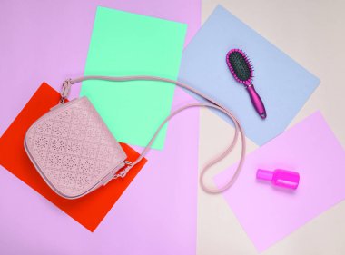 Deri çanta, tarak, pastel renkli bir arka plan üzerinde parfüm şişesi. Minimalizm. Top Vie