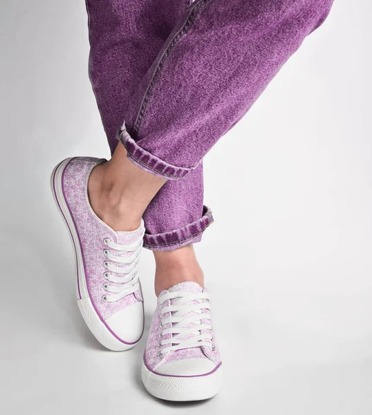 Frauenbeine Kurzen Jeans Und Turnschuhen Stehen Auf Weißem Untergrund — Stockfoto