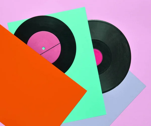 Vinyl plates on a colored pastel background. Retro musical attributes from the 80s. top view, minimalism. Copy spac