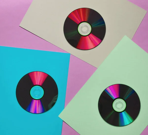 Computer CDs on a colored paper background. Retro Media. Top vie