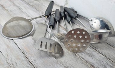 Beyaz duvara karşı yemek pişirmek için mutfak araçları kümesi.