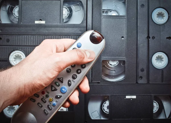 Närbild Fjärrkontrollen Handen Bakgrund Videokassetter Retro Media Teknik Underhållning Talet — Stockfoto