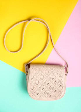 Pastel renkli bir arka plan üzerinde şık deri çanta. Minimalizm, top vie