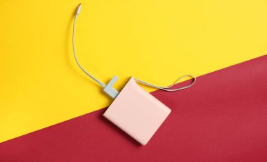 Sarı kırmızı kağıt arka plan üzerinde güç banka usb kablosu ile top vie