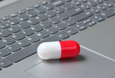 Dizüstü keyboar beyaz kırmızı tıbbi kapsül pill yakın çekim