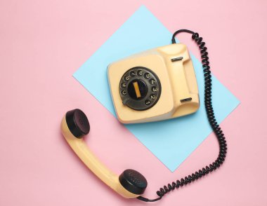 Pastel renkli bir arka plan üzerinde 80s Retro döner telefondan. Üstten Görünüm, minimalis